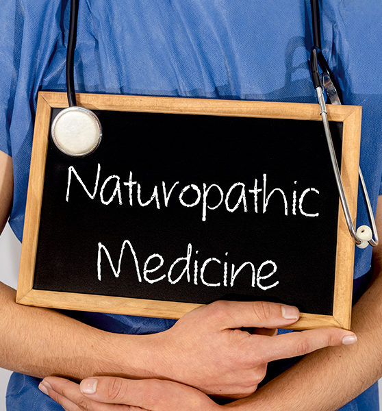Doctor shows information on blackboard: naturopathic medicine. Medical concept.